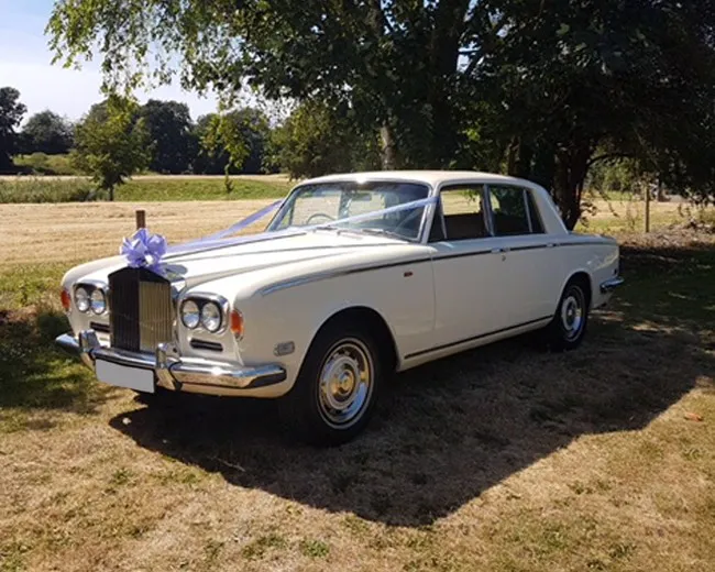Classic Wedding Cars: White 1974 Rolls-Royce Silver Shadow with wedding ribbons