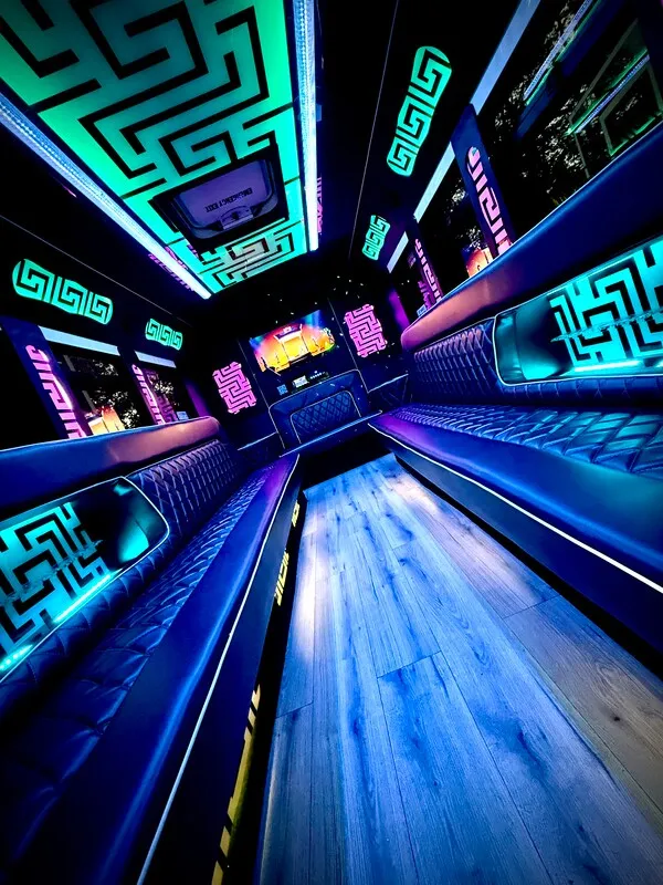 Ford E-450 Series Party Bus interior with perimeter lounge seating, LED accent lighting and LED ceiling lighting for party bus rental in North Attleboro, MA