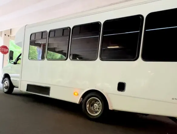 From outside of the white Ford E-450 Series Party Bus, showing tinted windows, shot 11
