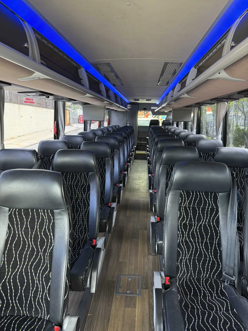 40 Passenger Charter Bus interior with LED accent lighting and overhead parcel racks for charter bus rental