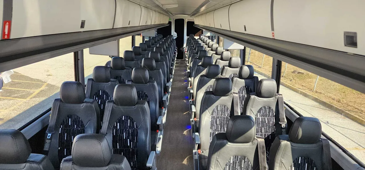 30 Passenger Charter Bus interior with overhead parcel racks for charter bus rental in Dallas, TX