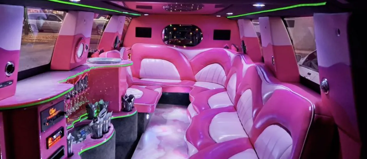 Chevrolet Suburban Limousine interior with sofa-style seating, LED accent lighting and bar area for limo rental in Jacksonville, FL