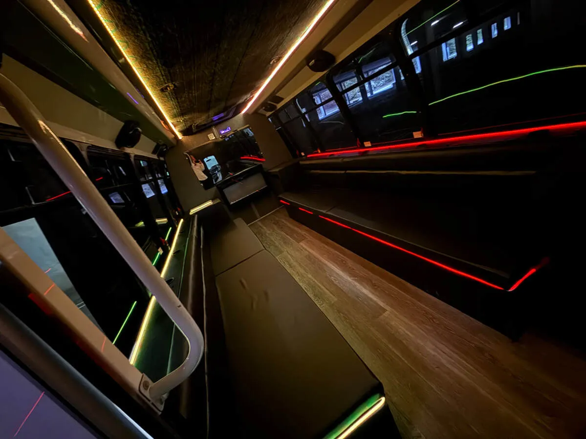 Ford E-450 Series Party Bus interior with perimeter lounge seating, LED accent lighting and LED ceiling lighting, photo 2 for party bus rental