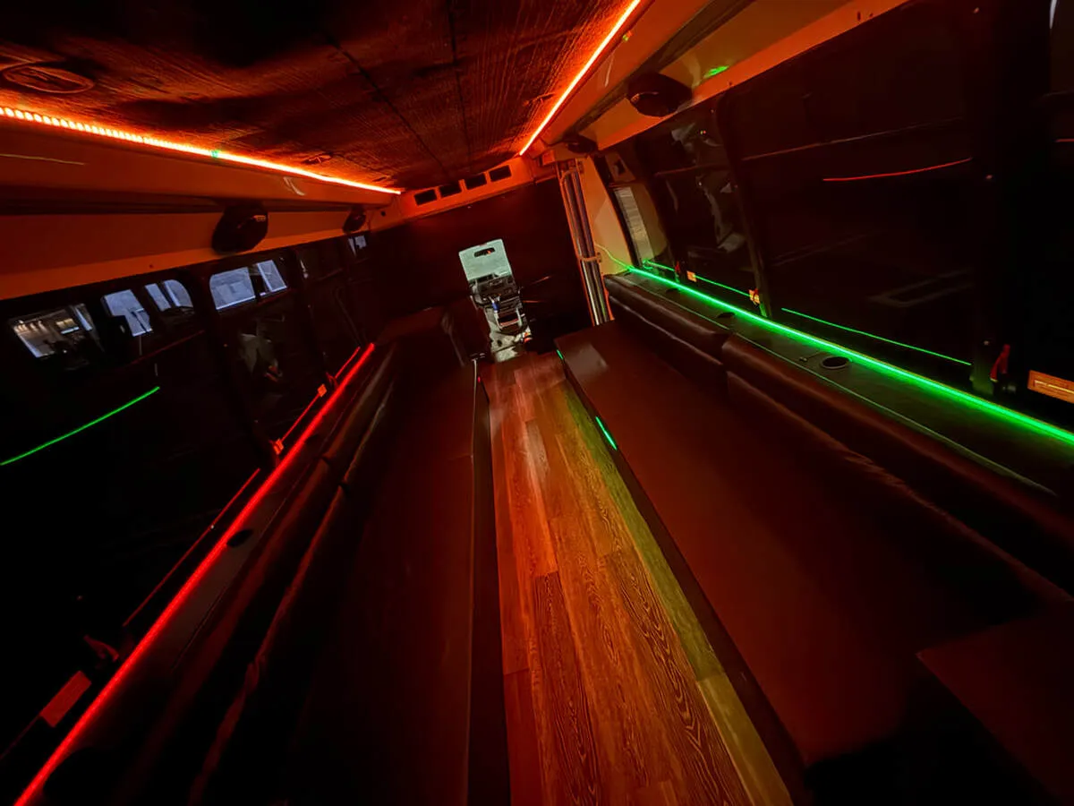 Ford E-450 Series Party Bus interior with perimeter lounge seating, LED accent lighting and LED ceiling lighting, photo 4 for party bus rental