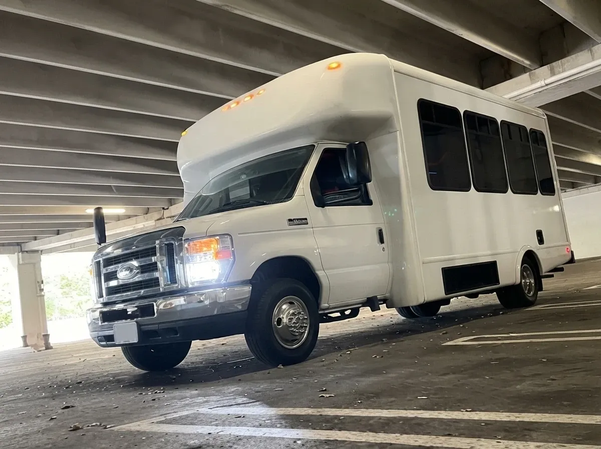 The white Ford E-450 Series Party Bus, ready to rent