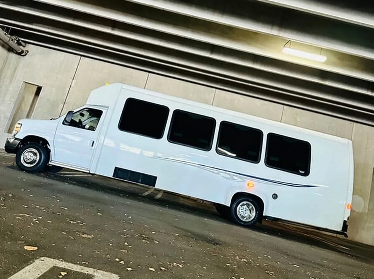The white Ford E-450 Series Party Bus, ready to rent