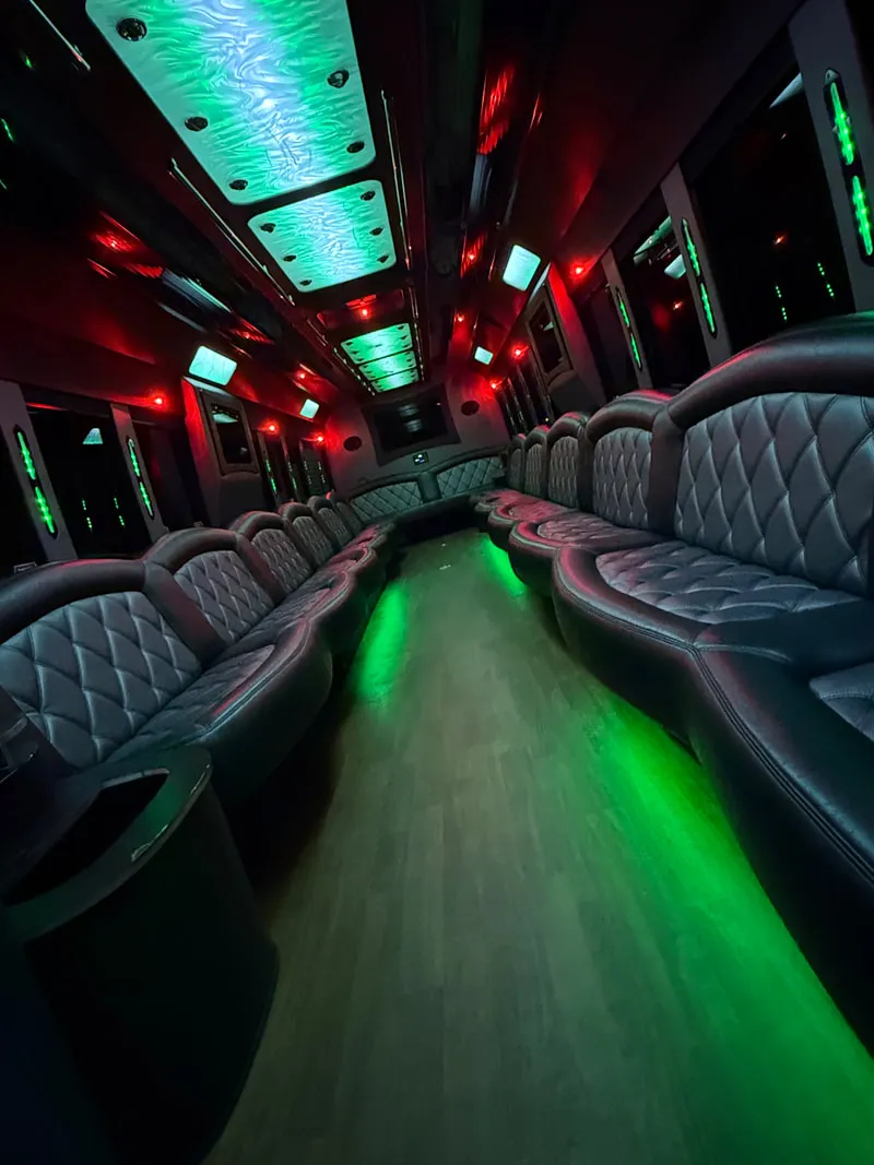 Freightliner Party Bus interior with perimeter lounge seating, LED ceiling lighting and wood-look flooring, photo 10 for party bus rental in North Attleboro, MA