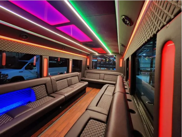 22 Passenger Limo Bus interior with perimeter lounge seating, LED accent lighting and LED ceiling lighting for party bus rental