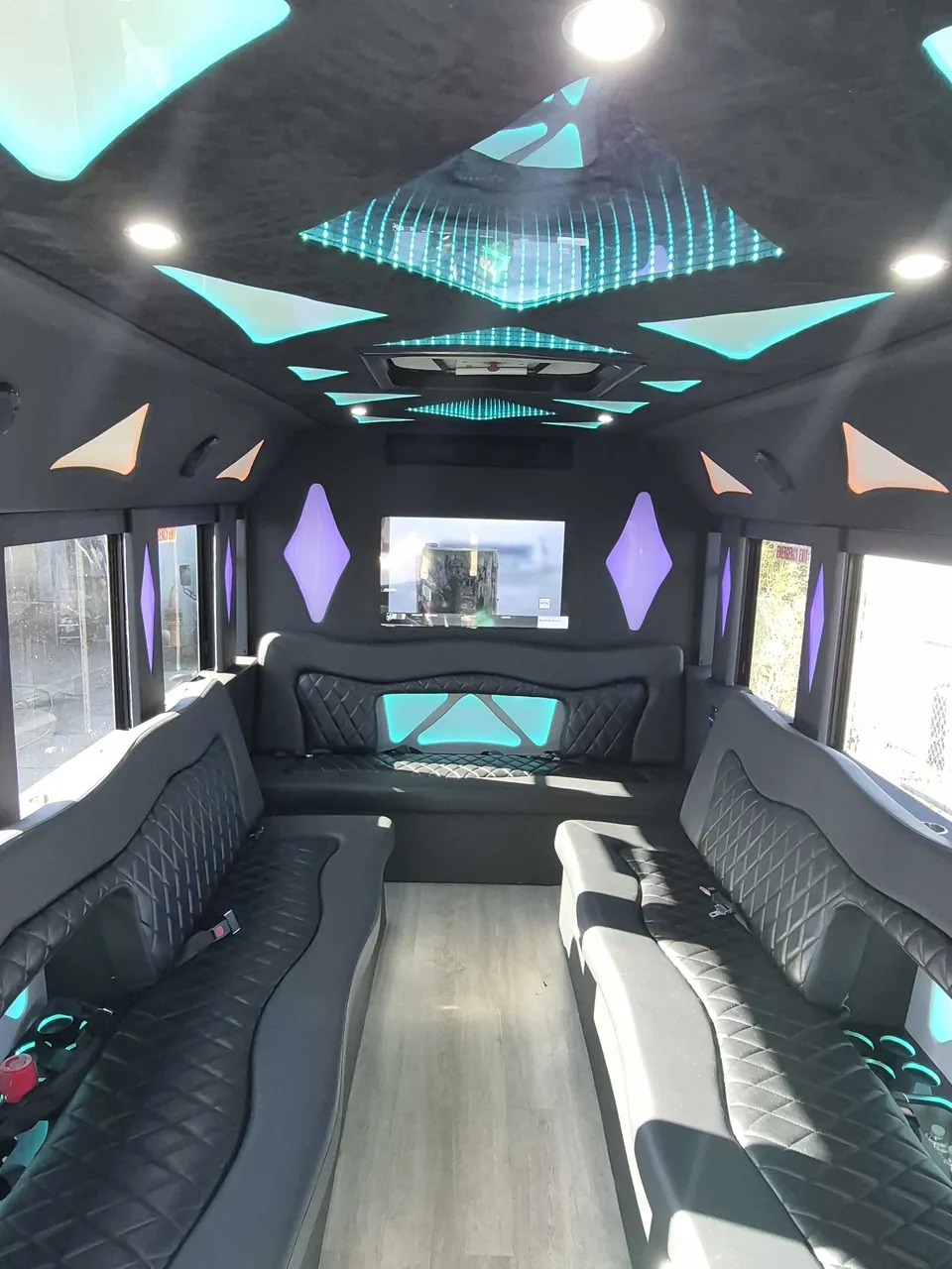 Limousine Bus interior with perimeter lounge seating, LED accent lighting and LED ceiling lighting, photo 3 for party bus rental