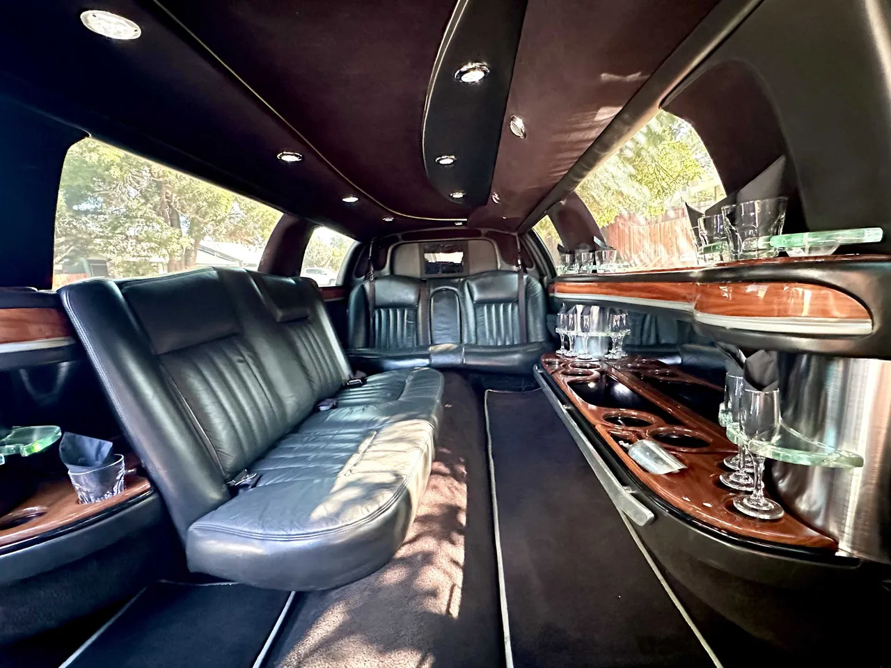 Lincoln Town Car Limousine interior with perimeter lounge seating, cup holders and bar area, photo 4 for limo rental in Hickman, CA