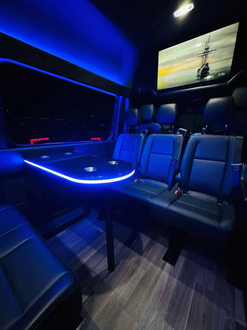 Mercedes-Benz Executive Sprinter interior with passenger tables, LED accent lighting and wood-look flooring, photo 3 for party bus rental