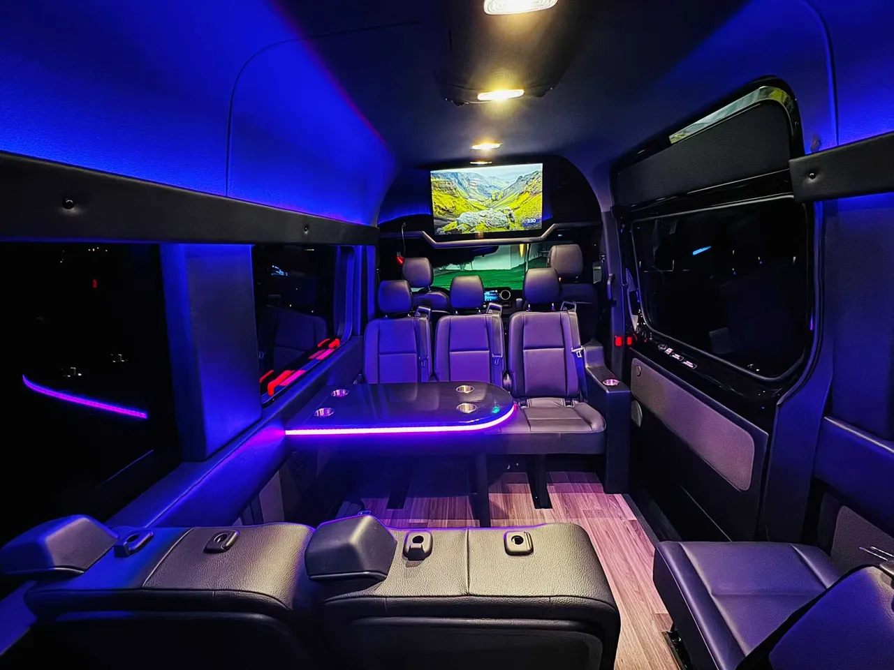 Mercedes-Benz Executive Sprinter interior with passenger tables, LED accent lighting and wood-look flooring, photo 2 for party bus rental