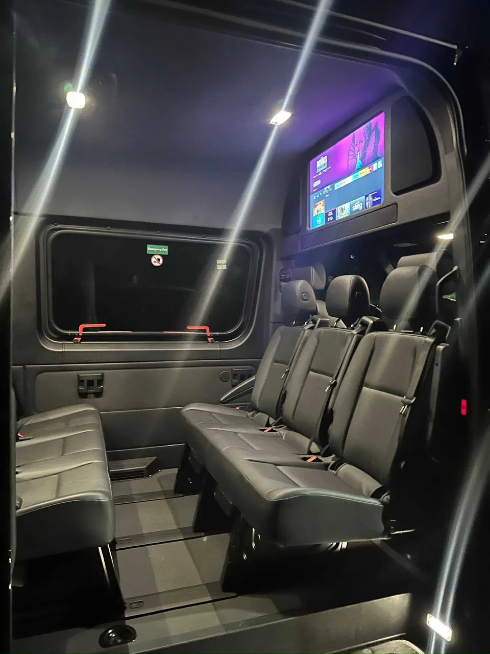 Mercedes-Benz Limousine Sprinter interior with TV screens and passenger seat belts for party bus rental