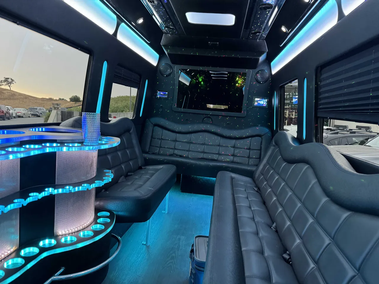 Mercedes-Benz Party Bus interior with perimeter lounge seating, window shades and LED accent lighting for party bus rental in Mather, CA