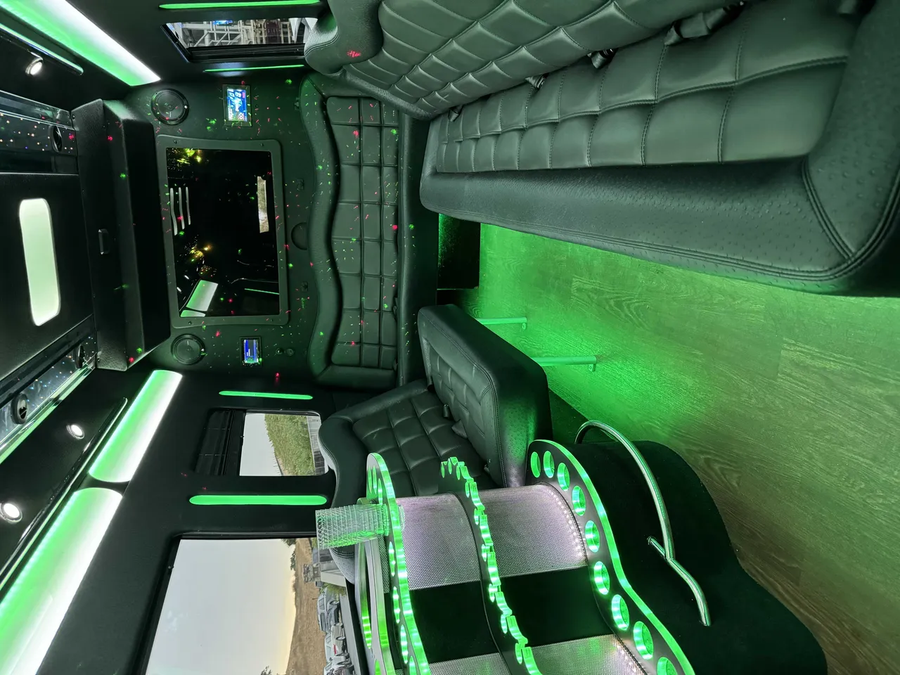 Mercedes-Benz Party Bus interior with perimeter lounge seating, LED accent lighting and wood-look flooring for party bus rental in Mather, CA