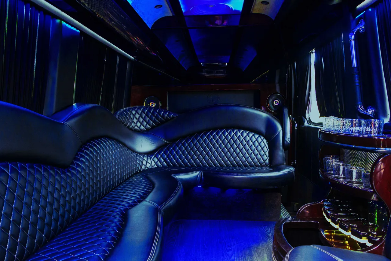 Mercedes-Benz Sprinter Limousine interior with sofa-style seating, window shades and bar area for party bus rental