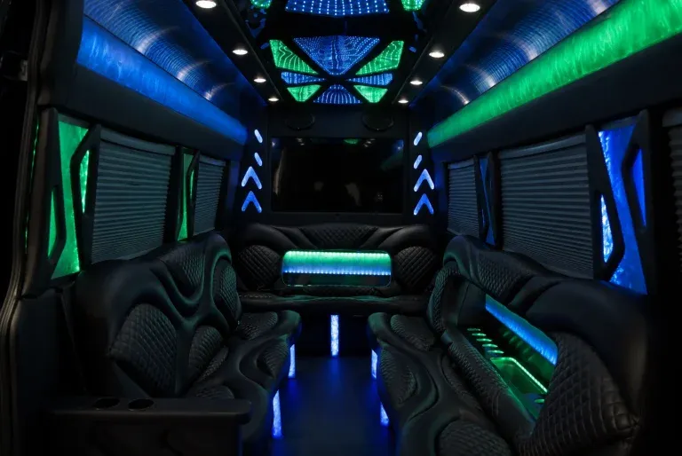 Mercedes-Benz Sprinter Limousine interior with perimeter lounge seating, window shades and LED accent lighting for party bus rental in El Paso, TX