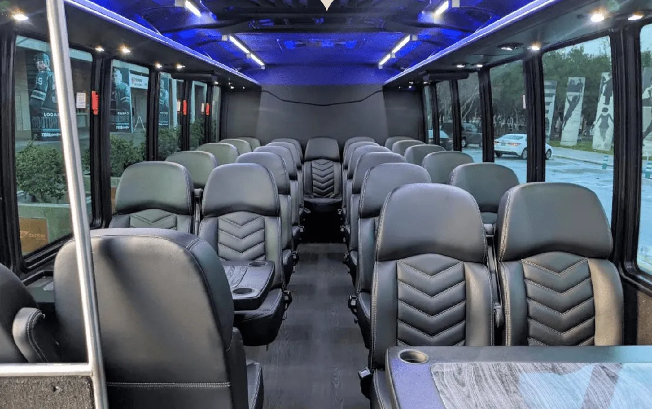 27 Passenger Mini Coach interior with passenger tables, cup holders and LED ceiling lighting for charter bus rental in Aromas, CA