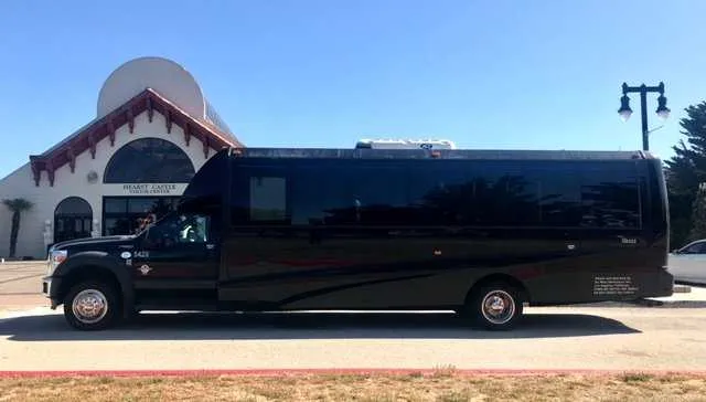 The black 28 Passenger Mini Coach, showing tinted windows