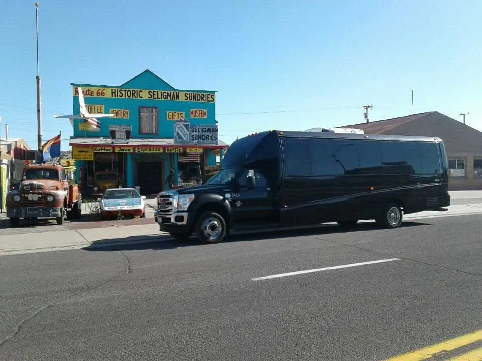 Black 28 Passenger Mini Coach with tinted windows for charter bus rental in La Habra, CA