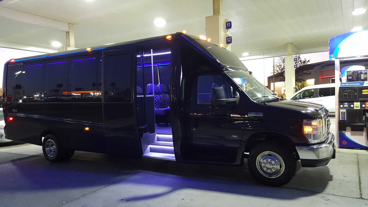 Black 31 Passenger Mini Coach with tinted windows and LED accent lighting for charter bus rental in Daly City, CA