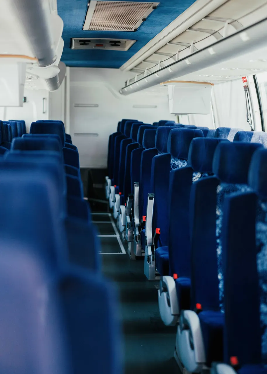 56 Passenger Motor Coach interior with overhead parcel racks for charter bus rental in Hacienda Heights, CA