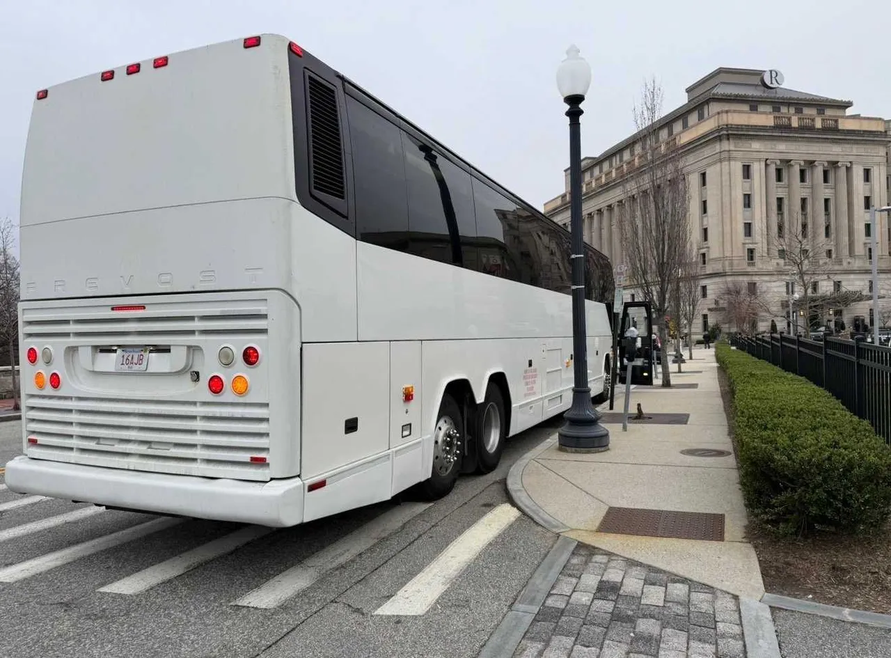 White 55 Passenger Motorcoach exterior with tinted windows for charter bus rental