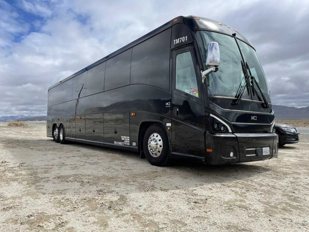 Black 56 Passenger Motorcoach exterior with tinted windows for charter bus rental in Keyes, CA