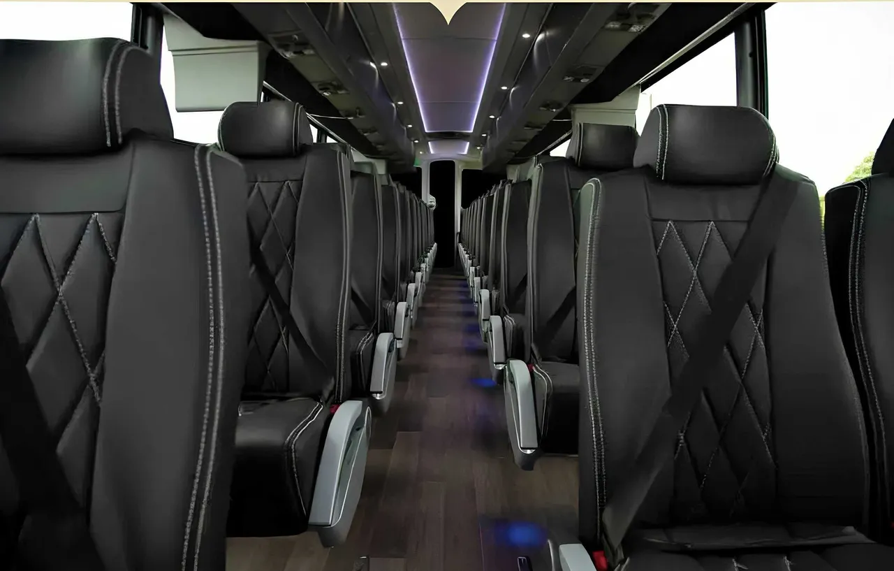 56 Passenger Motorcoach interior with LED accent lighting, LED ceiling lighting and passenger seat belts for charter bus rental in Keyes, CA