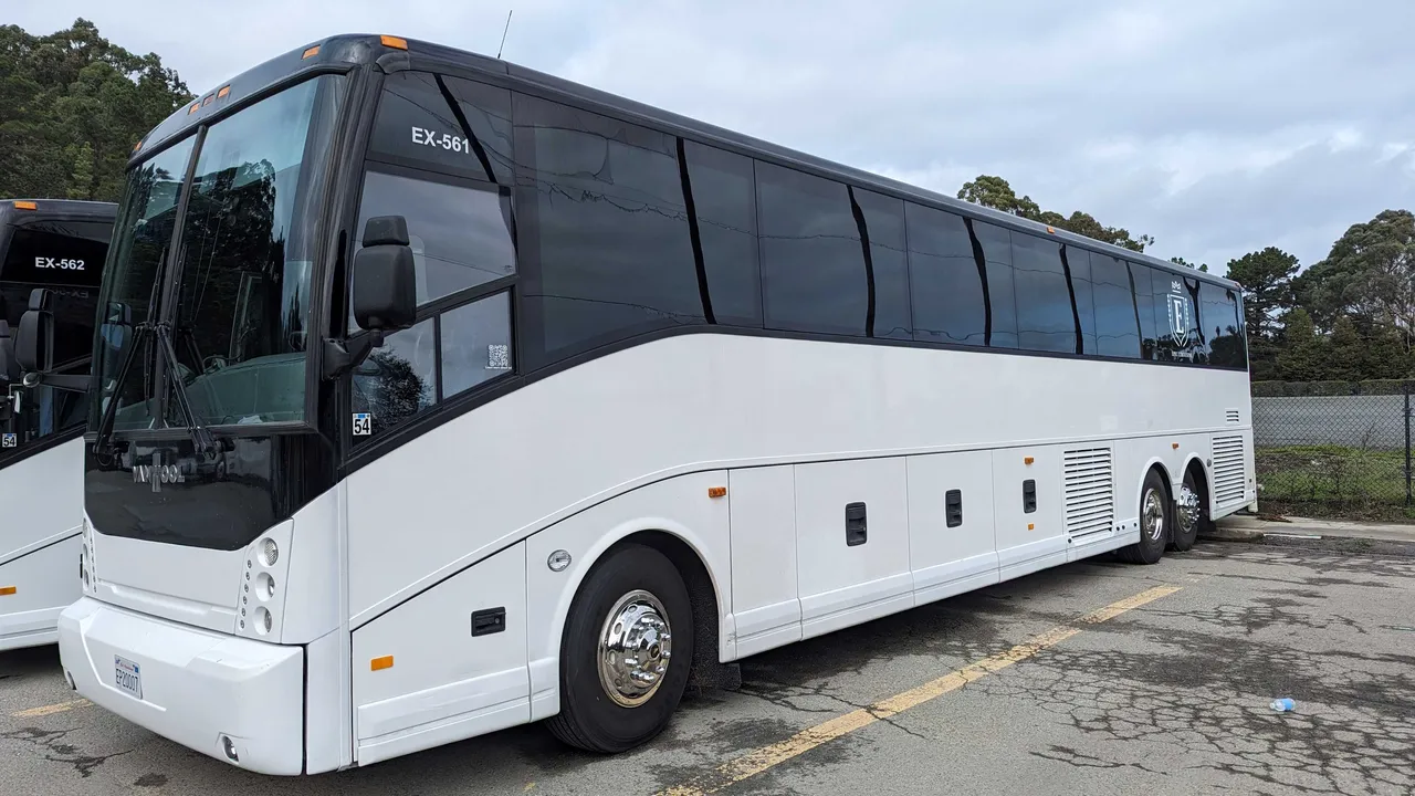 White 56 Passenger Motorcoach with tinted windows for charter bus rental in Daly City, CA