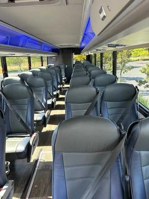 Inside of the 36 Passenger Motorcoach, showing LED accent lighting and overhead parcel racks