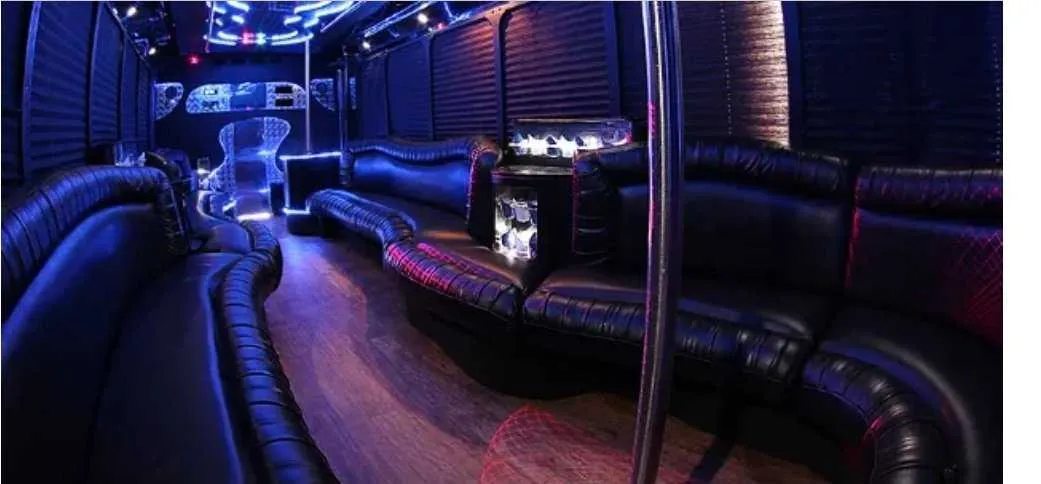 30 Passenger Party Bus interior with perimeter lounge seating, window shades and LED accent lighting for party bus rental in Schertz, TX