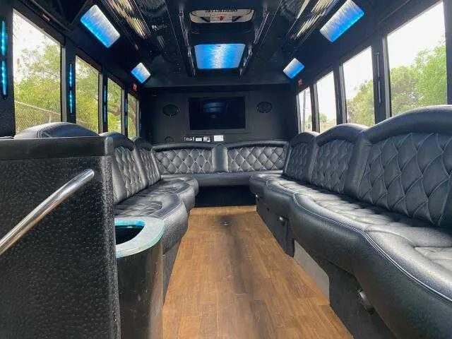 24 Passenger Party Bus interior with perimeter lounge seating, LED accent lighting and LED ceiling lighting for party bus rental in San Diego, CA