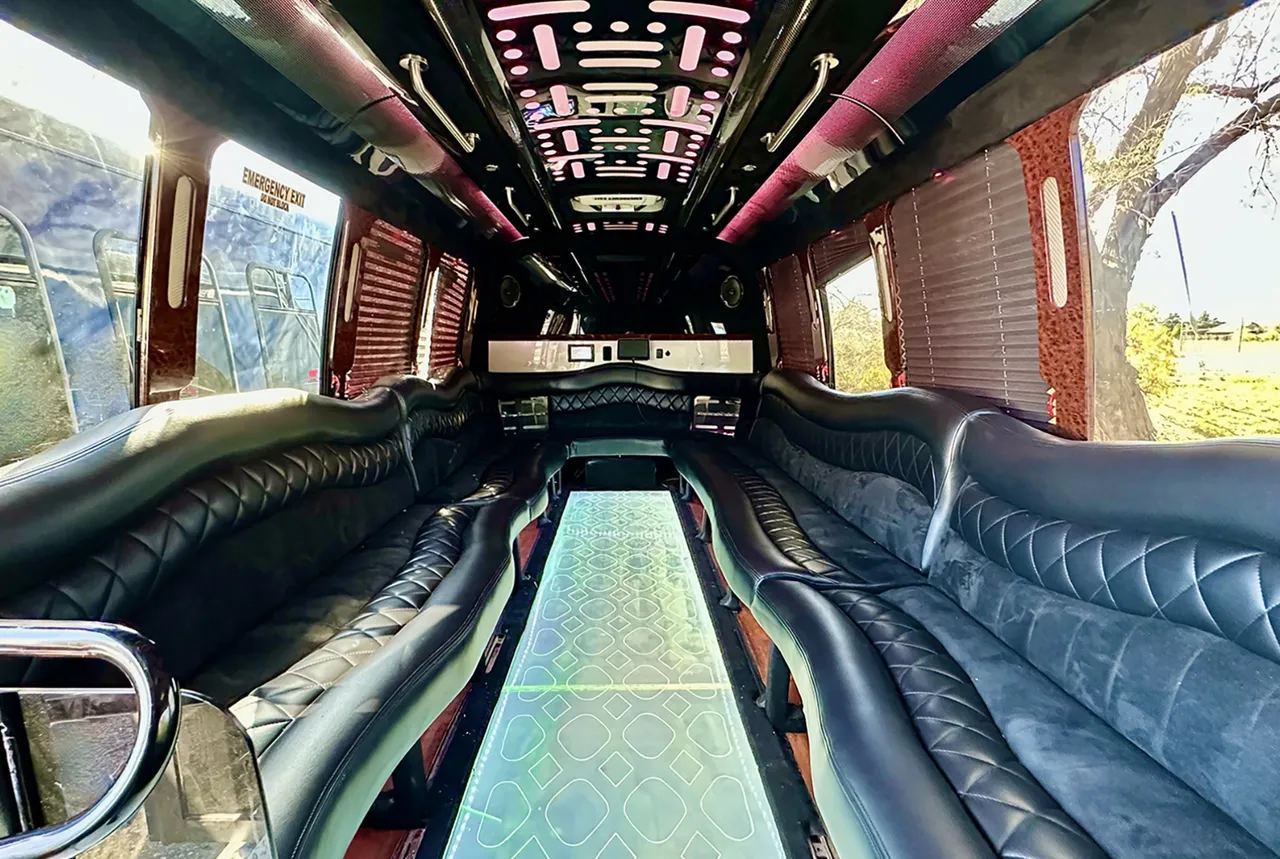 20 Passenger Party Bus interior with perimeter lounge seating, window shades and LED ceiling lighting for party bus rental in Golden, CO