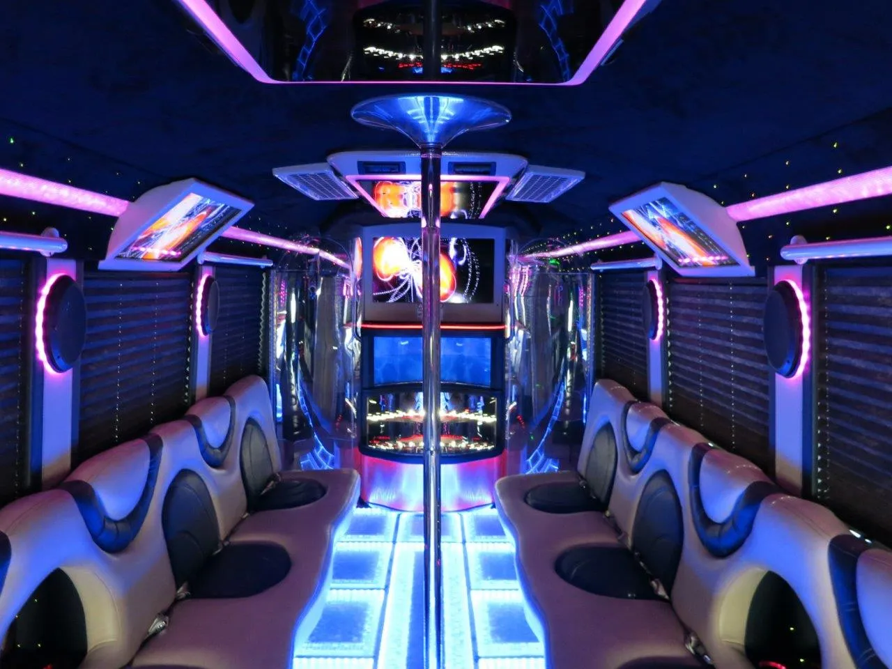 26 Passenger Party Bus interior with perimeter lounge seating, window shades and LED accent lighting for party bus rental in Keyes, CA