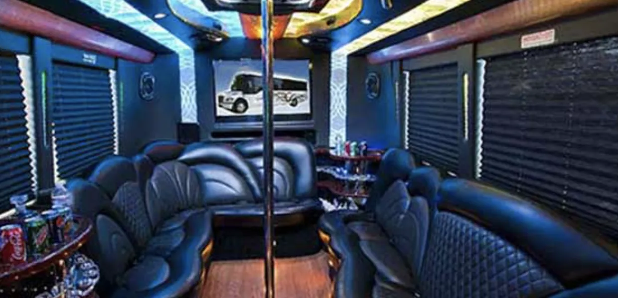 24 Passenger Party Bus interior with perimeter lounge seating, sofa-style seating and window shades for party bus rental in North Hollywood, CA