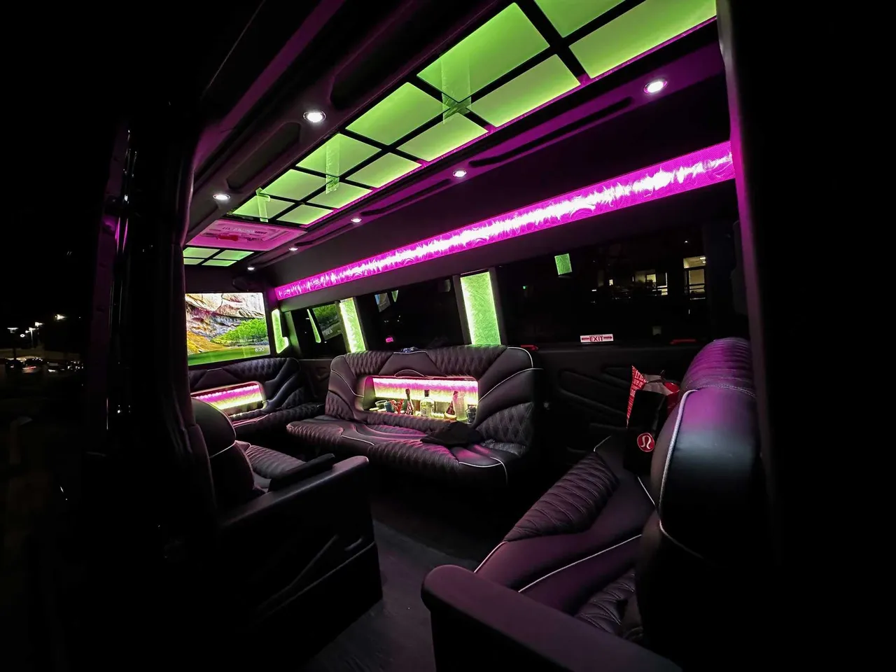 13 Passenger Sprinter Limousine interior with sofa-style seating, captain's chairs and LED accent lighting for party bus rental in San Diego, CA