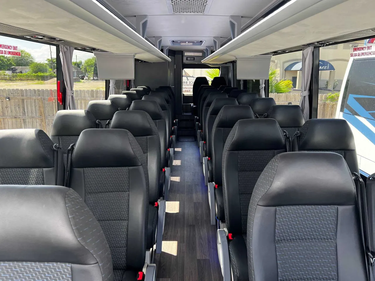 34 Passenger Charter Bus interior with window shades and overhead parcel racks for charter bus rental in Corpus Christi, TX